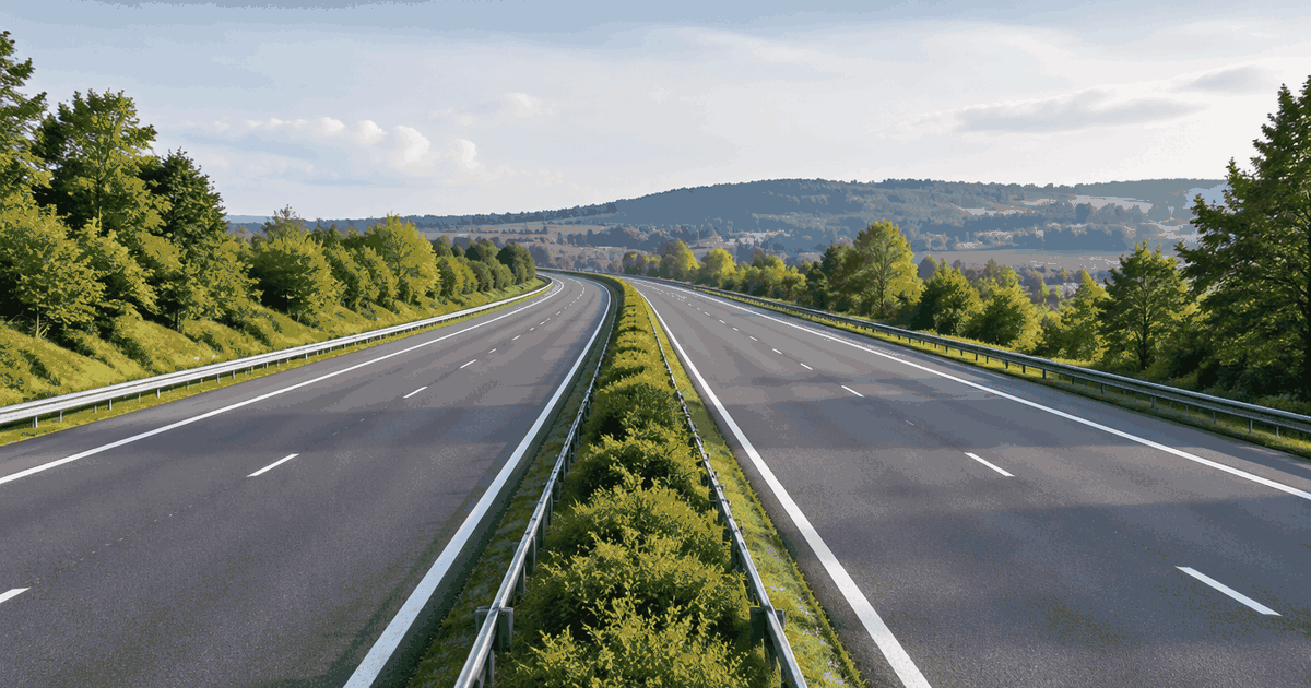 Belgische autoweg met gescheiden rijbanen, groene middenberm en Europees weglandschap